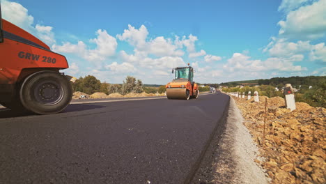 workers carry out construction and repair works of roads with the help of professional equipment near the city in the summer. close-up