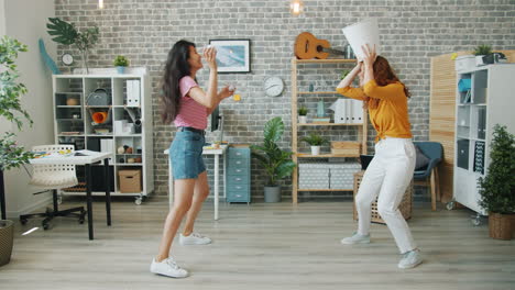 two women having fun in a modern office