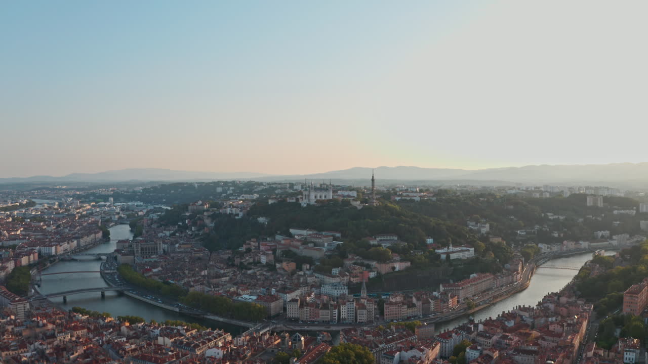 toma cinematográfica de un dron que rodea la basílica de lyon y el río ródano saona al atardecer
