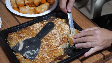 close-up view of a knife cutting traditional baklava into peaces