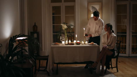 caring husband pouring wine at romantic date zoom on. couple having anniversary