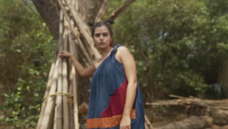 primer plano de una modelo de moda india con un vestido de moda sostenible azul, rojo y naranja en el bosque de goa, india en cámara lenta