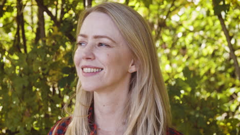 woman smiling outdoors in front of trees