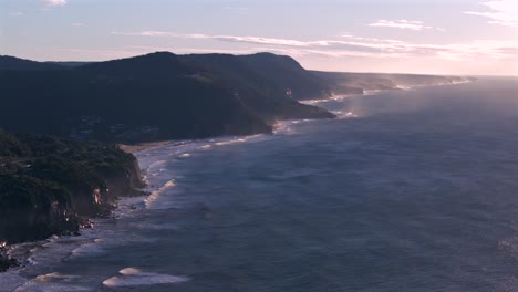 stanwell park bald hill top beach south coast coastline new south wales australia grand pacific drive sydney ocean waves crashing tourist holiday scenic nature landscape aerial drone circle pan left