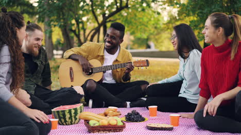 friends enjoying a picnic in the park with music