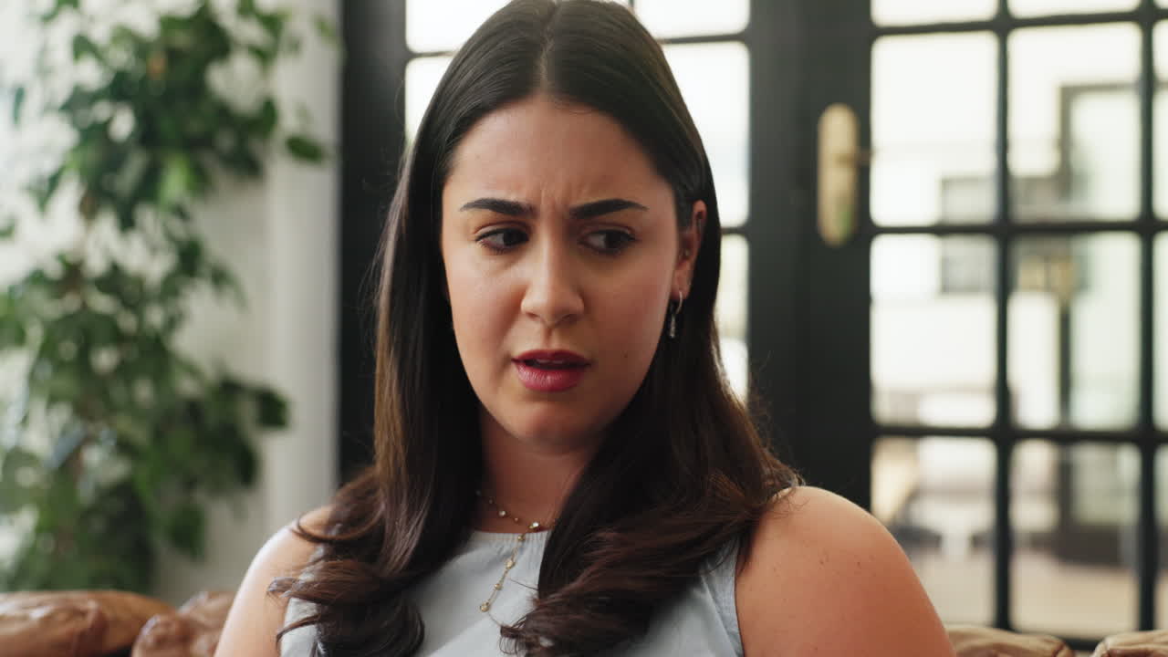 Young Woman with Worried Expression Looking at Her Phone