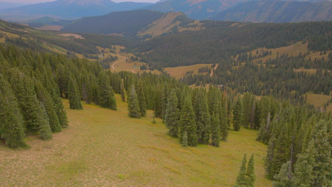 elevación aérea sobre árboles con montañas en el horizonte en crested butte en las montañas rocosas de colorado