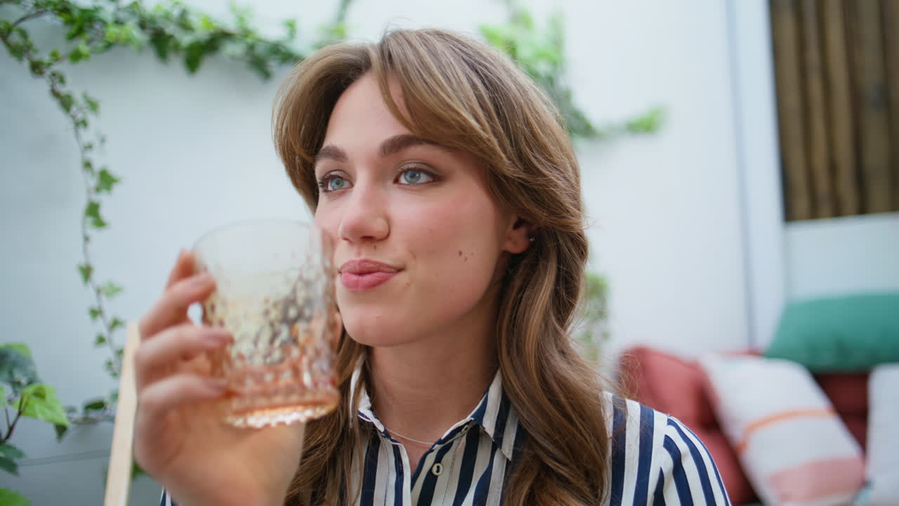 girl sipping beverage sitting patio closeup. Woman drinking whiskey