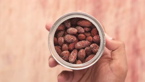 almendras azucaradas enlatadas en la mano