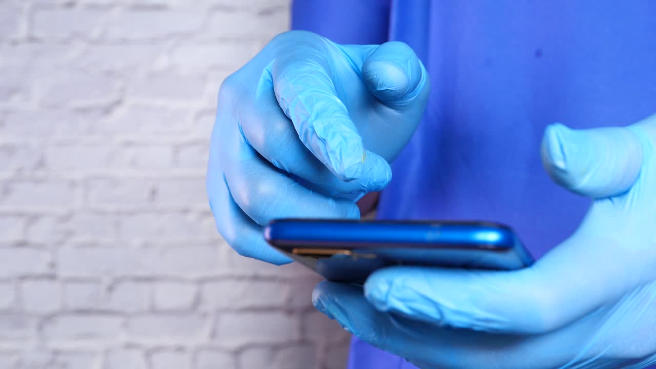 장갑을 입고 스마트폰을 사용하는 사람