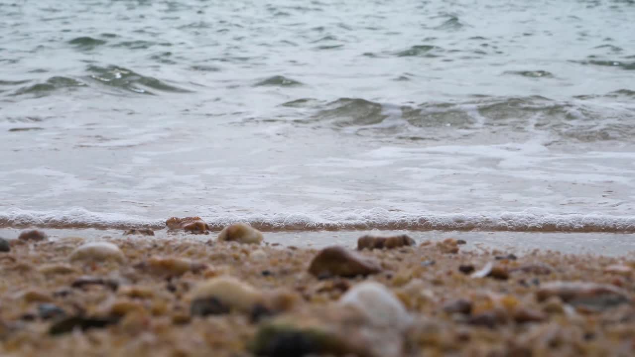 홍콩에서 일몰 동안 해변 모래를 흠뻑 적시는 썰물 바다의 거품이 이는 파도의 전망