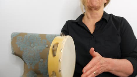 close up view of a woman playing tambourine, no face, dolly out