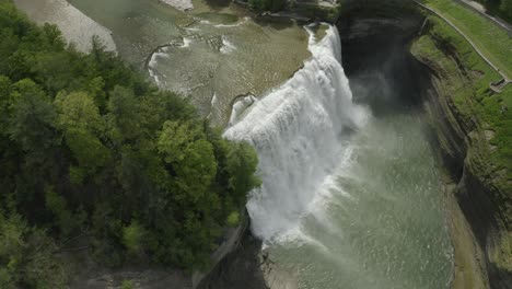 drone shot, flying around a waterfall, while panning down