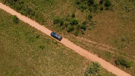 Camión-Conduciendo-Por-Un-Camino-De-Tierra,-Tiro-De-Seguimiento-De-Drones-Aéreos