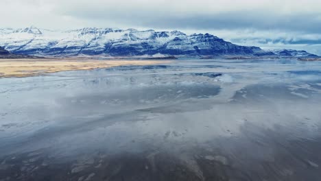 Snowy-rocky-mountains-at-lakeside-on-winter-day