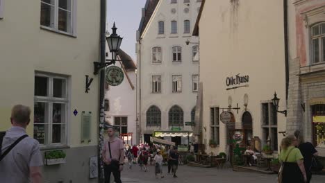 slow motion tilt down over pedestrians walking through old streets of tallinn, estonia