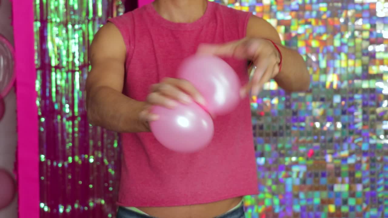 girando globos rosados en formas en una configuración de fiesta colorida y brillante