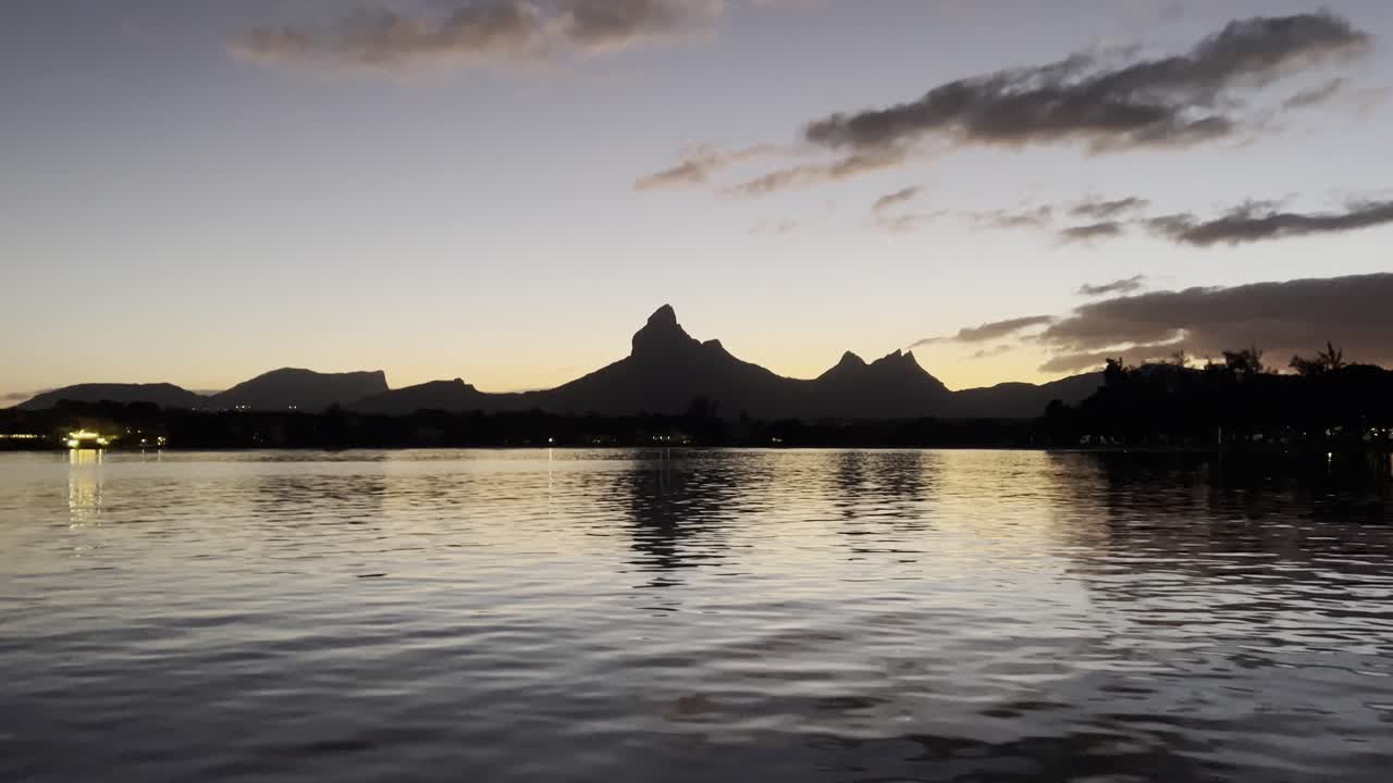 A glamorous early morning shot of the Rempart mountain is viewed from the sea in Tamarin Bay, with an upward movement from water to mountain.
