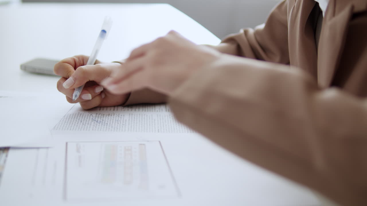 un individuo enfocado escribe meticulosamente un informe que muestra dedicación y atención a los detalles.