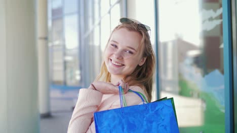 happy woman with shopping bags outside a store
