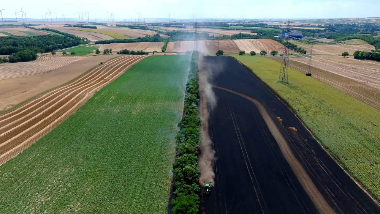 Farmer Ploughs A Burning Field To Contain The Fire - aerial pullback