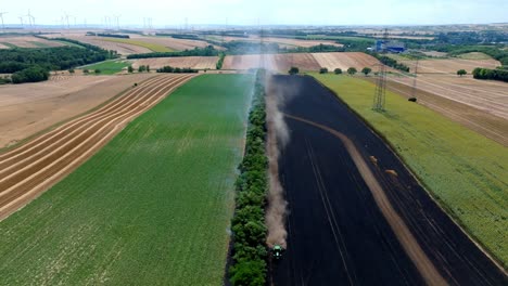 el agricultor ara un campo en llamas para contener el fuego - retirada aérea