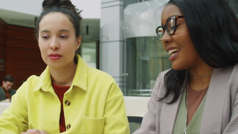 Multiethnic-Businesswomen-Working-on-Laptop-and-Talking-in-Office