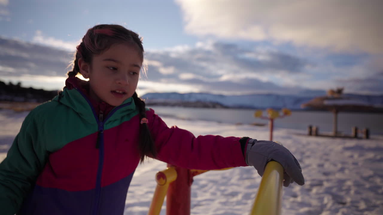 Primer plano de una niña con ropa colorida de invierno jugando en un parque nevado, vacaciones de invierno, Argentina