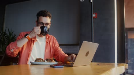 hombre trabajando en una computadora portátil en un café