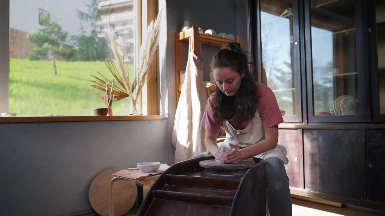 mujer trabajando en la rueda de cerámica