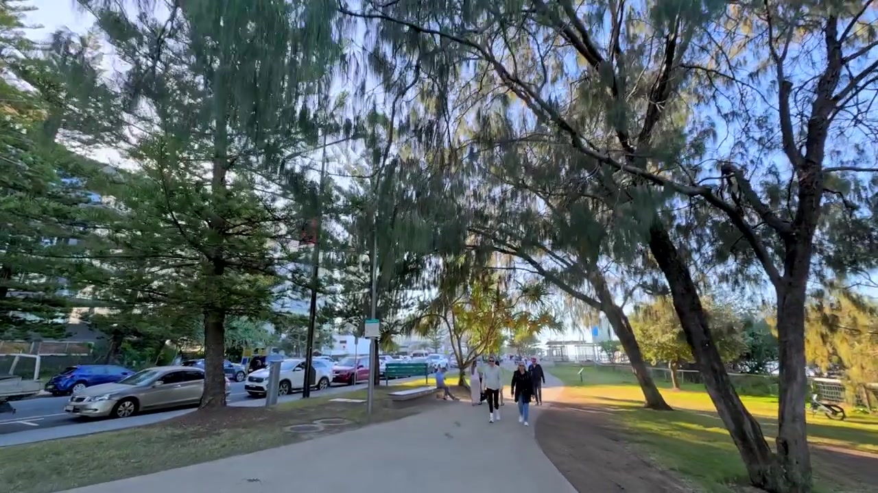 Plano de seguimiento de gran angular de personas caminando por un sendero costero soleado en Australia