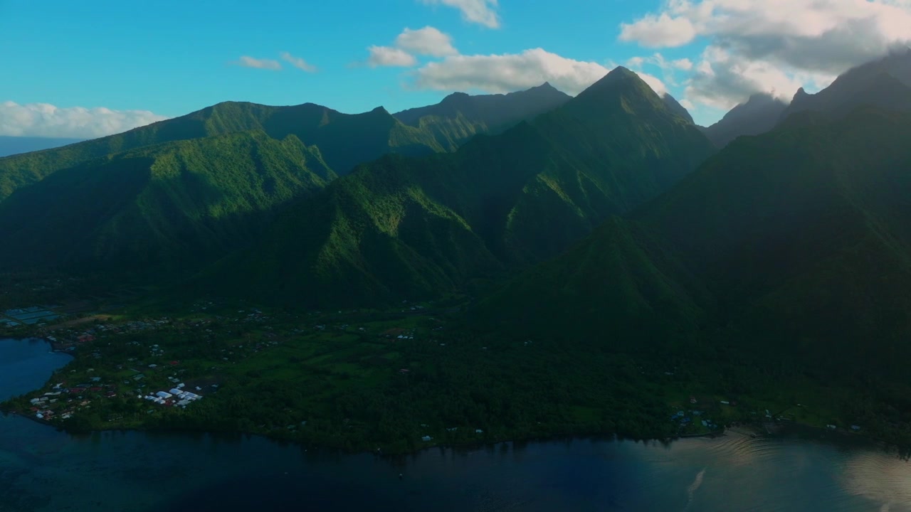 Tahiti lagoon sun rays landscape aerial drone harbor view French Polynesia Teahupo'o surf wave Passe Havea coral reef South Pacific Ocean island golden sunny volcano peaks low clouds coastline circle