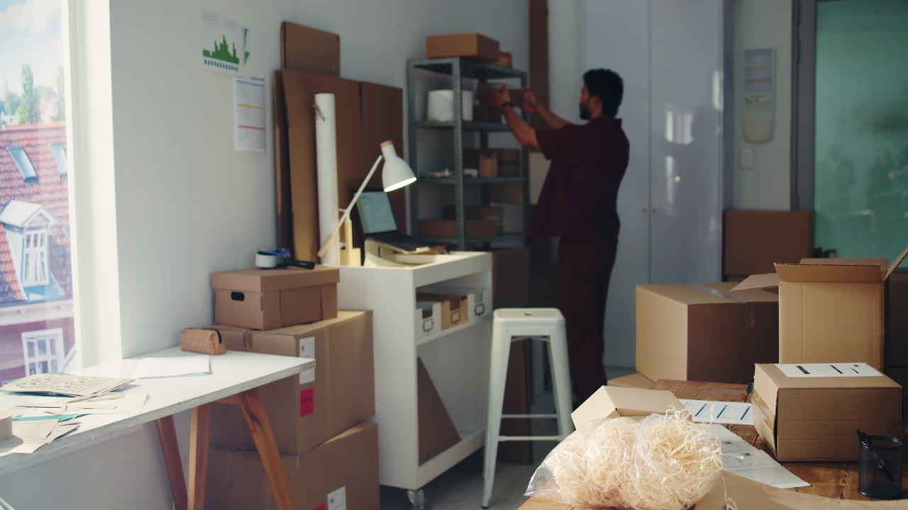 Young Man Working on Shipping Orders in Small Business Office