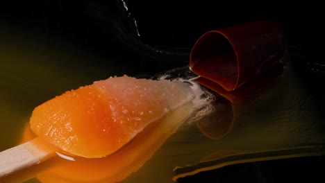 rocket popsicle melts on a reflective surface on a black background