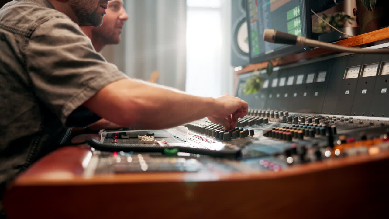 Sound engineer using a mixing console in a professional audio studio