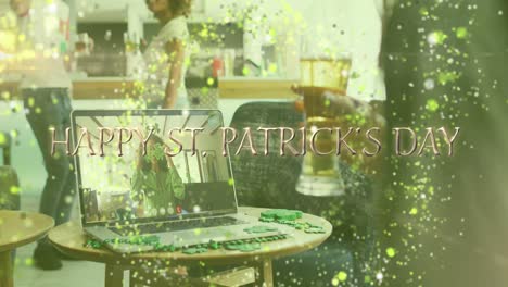 animation of happy st patrick's day text over man celebrating with friends on laptop video call