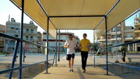 Father-and-Son-in-Headphones-Jogging-in-Resort-City