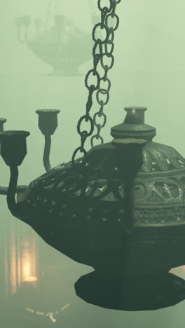 close-up of an ornate, old-fashioned chandelier hanging in a dimly lit room