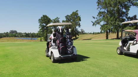 senior people driving a golf cart with clubs on the back at golf course