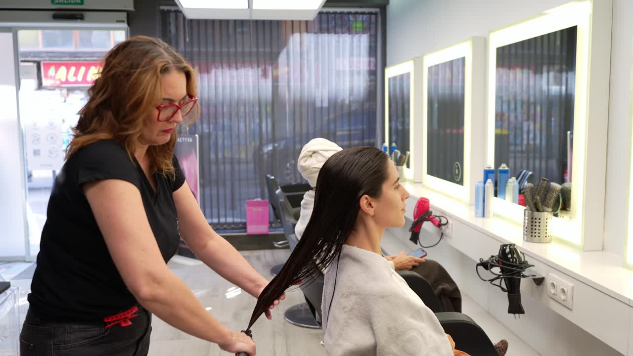 Hairdresser Combing Client's Wet Hair in a Modern Salon