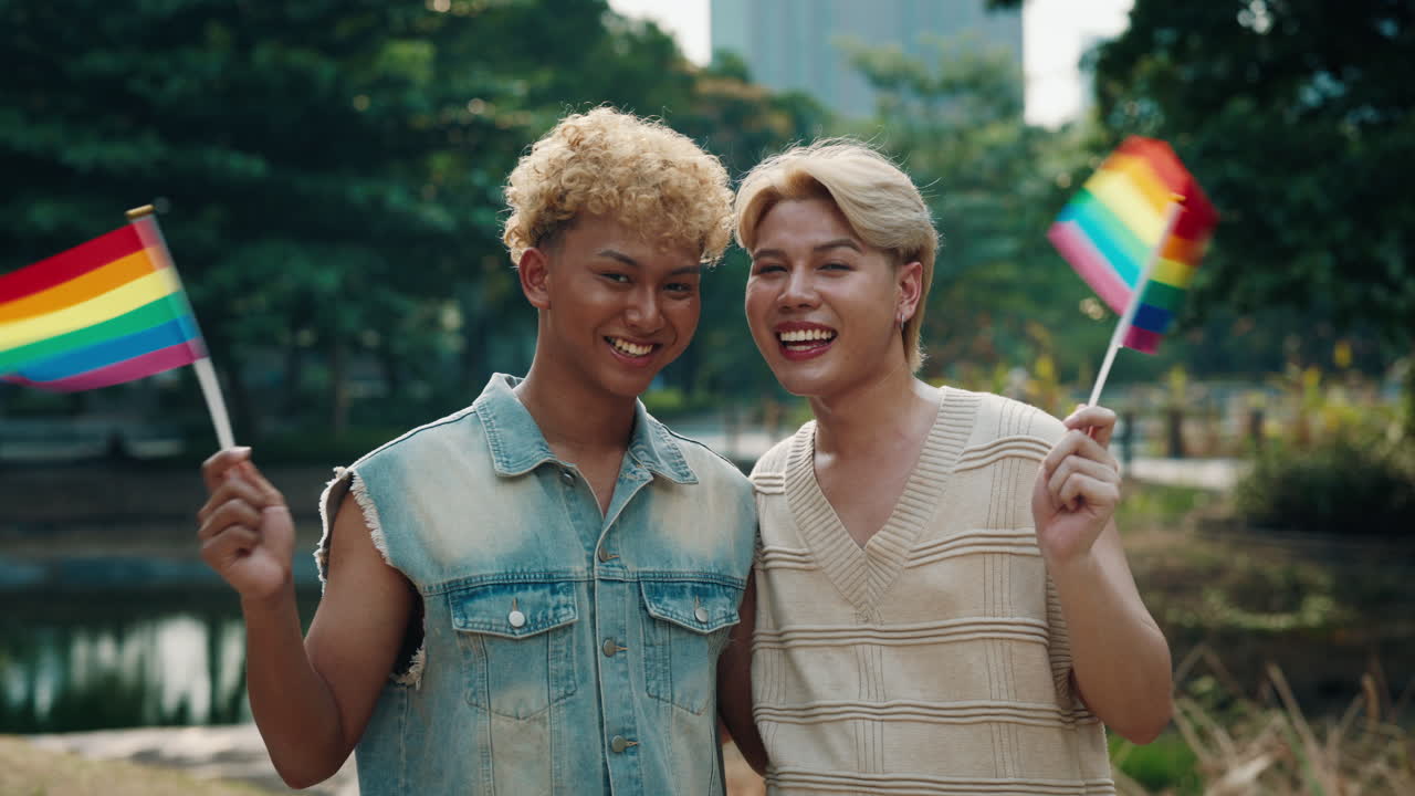 A loving same-sex couple celebrating pride with rainbow flags