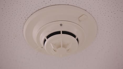 primer plano de una alarma de humo con una pequeña luz parpadeando