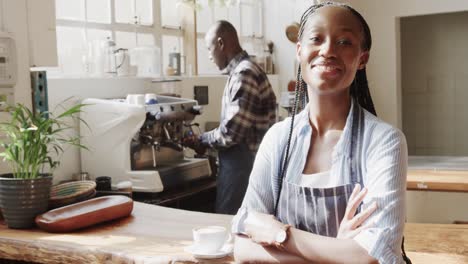 portrait of happy african american male and female coffee shop owners at work, slow motion