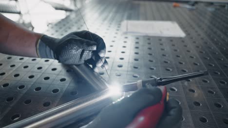 metalworker is mig welding two stainless steel tubes together