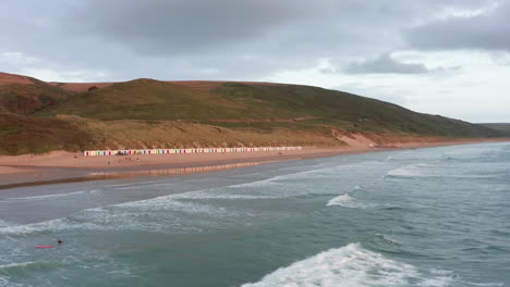 Camión-Aéreo-De-Una-Playa-De-Arena---Surfistas-Al-Atardecer-Durante-El-Verano