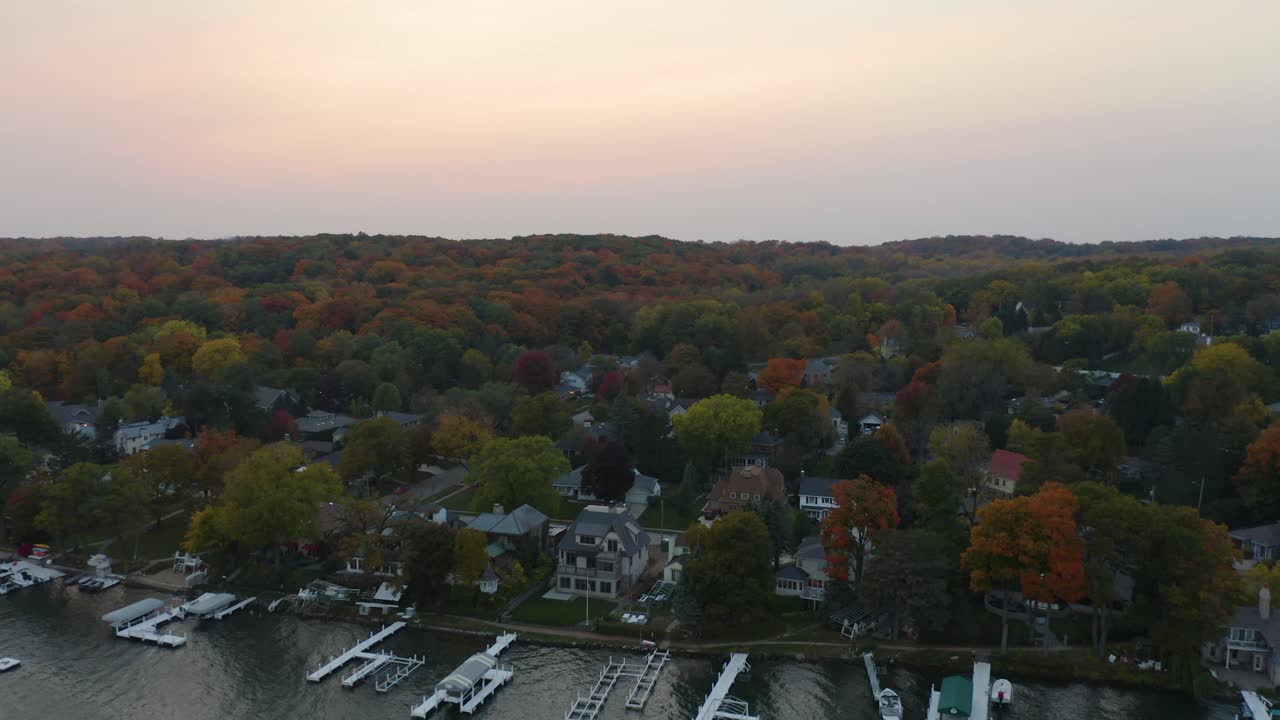 toma aérea de establecimiento, casas frente al lago con muelles para botes