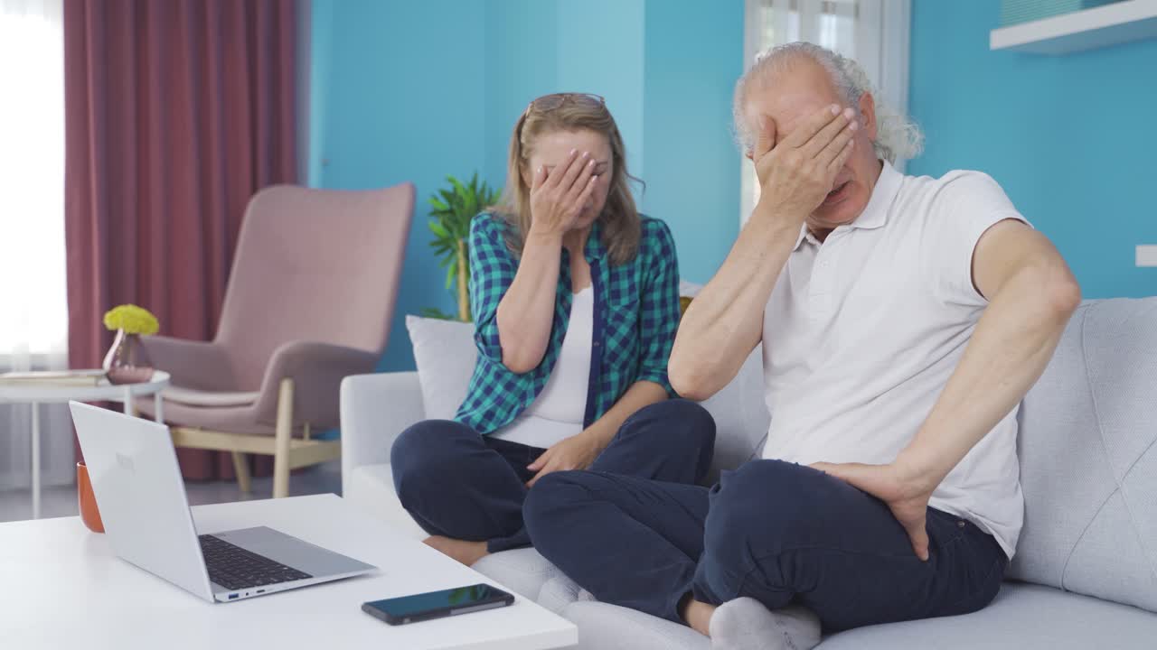 결혼한 부부가 집에서 노트북에서 공포 영화를 보고 있습니다.