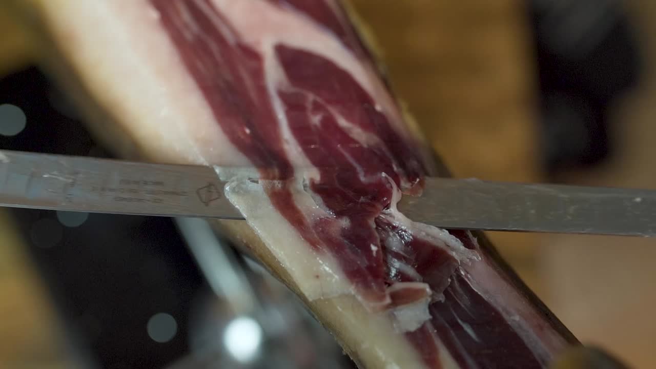 primer plano de seguimiento de cuchillo afilado rebanado fino jamón serrano español