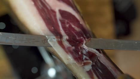 Primer-Plano-De-Seguimiento-De-Cuchillo-Afilado-Rebanado-Fino-Jamón-Serrano-Español