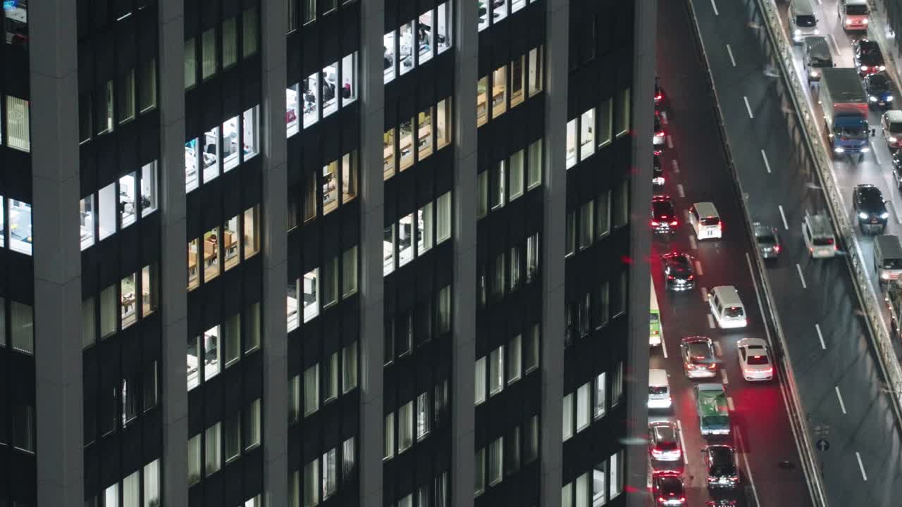 edificio de oficinas al lado de una carretera con mucho tráfico en la noche en shibuya, ciudad de tokio, japón